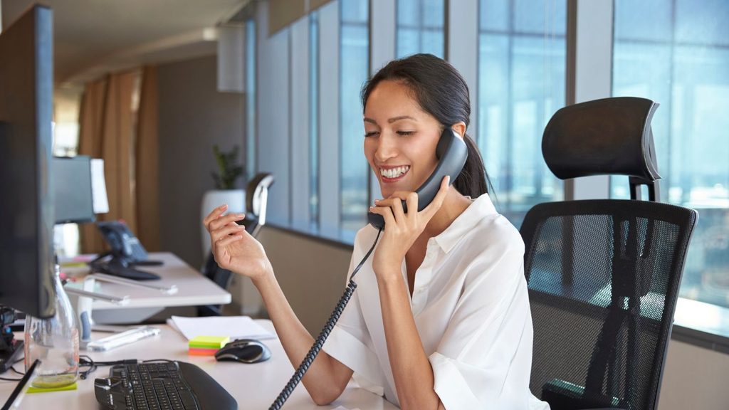 Professionnelle utilisant un téléphone de bureau dans son espace de travail